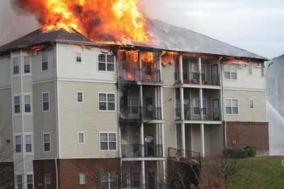 (5) Fire entering the void space can become a structure fire on steroids, especially if it becomes wind driven. This fire started on the exterior of the structure and rapidly spread up the vinyl siding, breaching the vinyl soffit, and quickly involved the attic voids. The building's sprinklers did not activate because of the fire's location. [Photo courtesy of the Sterling (VA) Volunteer Fire Company.]