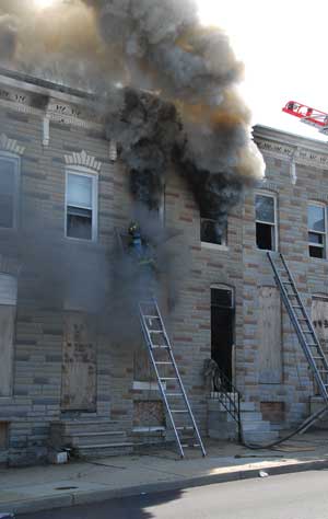 (3) The coordinated attack on the fire: a charged hoseline advancing on the fire with properly timed ventilation. (Photo by Howard Meile III.)