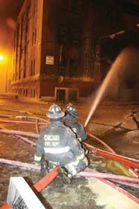 (4) A CFD engine company operates a portable deck gun onto the fire building. The fire extended to an adjacent exposure but was quickly stopped by determined firefighters and well-placed water from master streams.