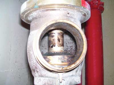 (13) A look inside a hose outlet: Note that the valve's floating stem has no threads, and observe the hole in the valve's stem, which is an inlet for the stem's waterway.