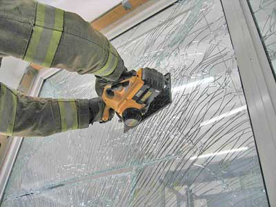 (27) Firefighters practice cutting laminated impact-resistant glass with a battery-operated circular saw. Cutting with battery-powered saws will be faster if the glass is first 