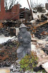 (3) Three major fires occurred in the Rockaways during Hurricane Sandy. Firefighters were hampered by the high storm surge. This fire was in Belle Harbor, Queens; almost three blocks of structures were destroyed. On November 1, 2012, this firefighter statue was the only thing standing after the massive fire. A firefighter probably owned this home. 