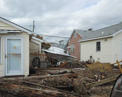 (4) This photo illustrates the typical damage inflicted on South Queens residents. In addition to the damage caused by the surge, buildings were impacted by floating debris that included buildings dislodged from their foundations, vehicles, boats, boardwalks, decks, and sand.