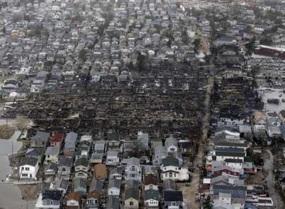 (5) An aerial view of the damage from the Breezy Point fire. The fire started on the ocean side (the left of the photo) and was blown by hurricane winds to the west and then to the north. Firefighters stopped the fire and saved numerous homes only after losing 111 buildings. Approximately 20 percent of the community sustained catastrophic damage from fire and flooding. Almost all homes sustained significant damage. 