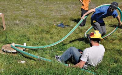 (3) California Polytechnic State University fire protection engineering students conduct a test to measure hose kinking associated with CAFS. (Photo by D.R. Turner.)