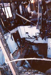 (2) This is a shot of the fire unit looking from the D exposure. All the floors pancaked right down into the garage. Note where the trusses were ripped out of the floor void because of the impact load of the collapsing floors. (Photo by author.)