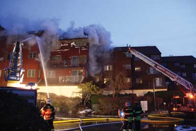 (4) This is a photo of early conditions. We have gone defensive. The Bravo exposure is at the extreme left, and the Delta exposure is partially obscured by smoke. This view shows where the command post is set up, at the rear of the buildings. (Photo by Ron Jeffers.)