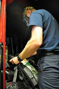 (1) A firefighter checks his SCBA on arrival at the scene. (Photos by Woody Woodward.) 