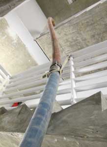 Hose suspended in the well opening is supported by tubular webbing to take the strain off the couplings. 