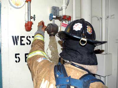 Firefighters flush a conventional standpipe outlet before connecting a hoseline. 