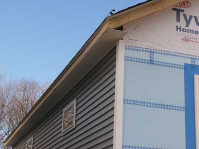 The soffit on the load-bearing side is open and covered with vented vinyl siding to allow air in