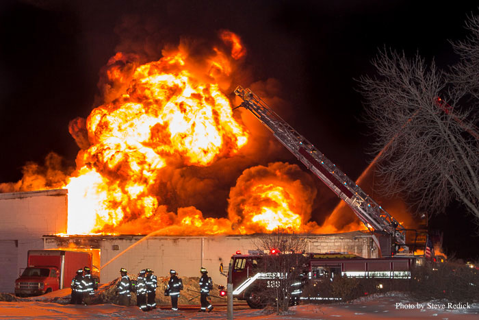 Massive flames shoot from the structure as firefighters operate at the scene. Photo by Steve Redick.