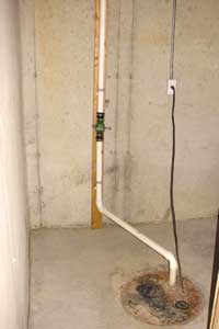 This sump pump pit is on an exterior wall in a home's basement.