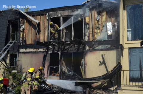 Firefighters train two hosestreams at the scene of the fire.