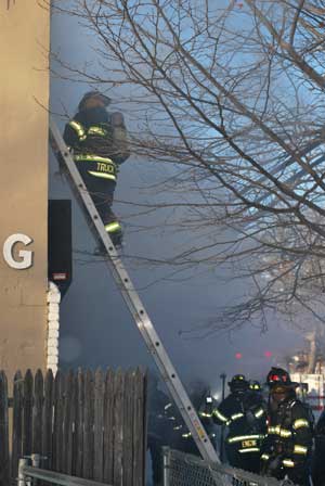 (8) A member on a ladder gets ready to enter the apartment above the B side store. Another member foots the ladder, an extremely important safety measure especially in inclement weather.