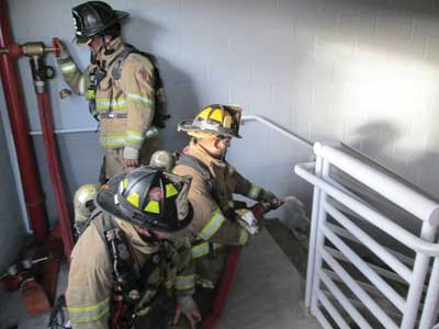 nozzle is flowed on the stair landing below the fire floor