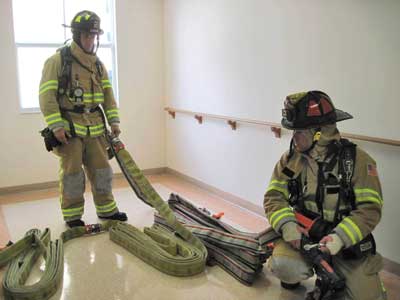 100-foot flat load and two 50-foot Denver loads are deployed on the floor below the fire