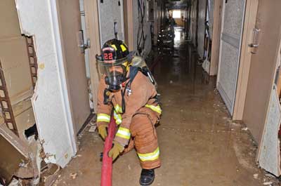 third firefighter on the nozzle team, positioned between the attack stairwell and the nozzle