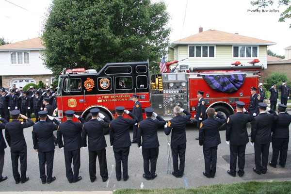 Firefighters salute at the funeral for firefighter John Barnas.