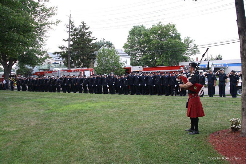 A bagpiper plays as firefighters assemble at the ceremony.