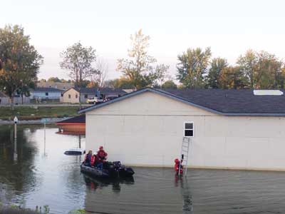 (3) A water rescue team accessing a window in the flooded community.