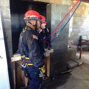 (5) Members of the District 8 search and rescue team make entry into an elevator shaft for victim rescue.