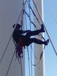 (6) A member of the District 8 technical rescue team ascends a rope to rescue a worker suspended from the water tower.