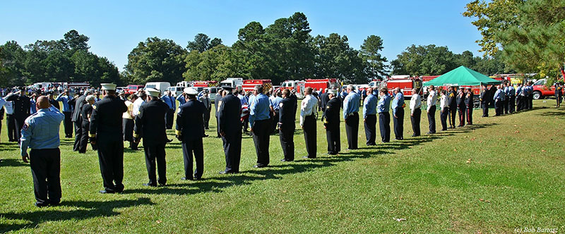 Fire officials salute the fallen firefighter.