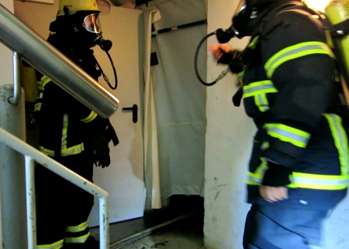 Firefighters in the stairway outside the fire compartment.