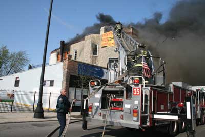 Members are advancing a hoseline to the roof because the roof covering has caught fire. 