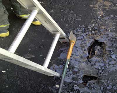 (7) When hopping roofs to gain access to upper windows or a rooftop, be sure to secure the ladder. Here the pick of an ax is buried into a roof decking.