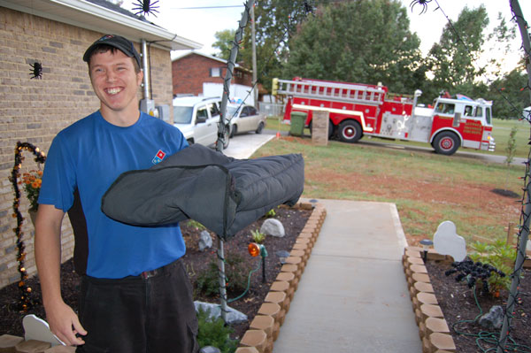 A firefighter makes a home pizza delivery during Fire Prevention Week 2014.