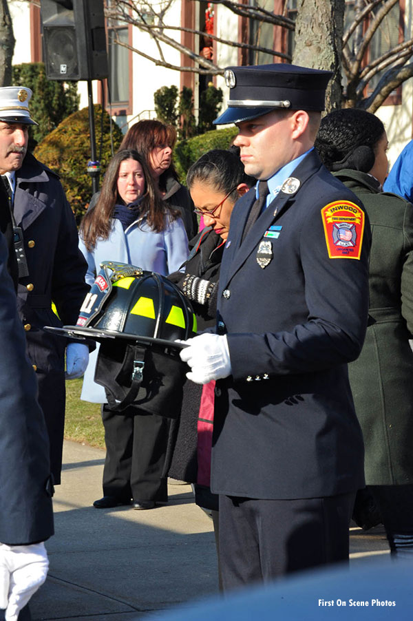 A firefighter bearing a helmet at Sanford's funeral service.