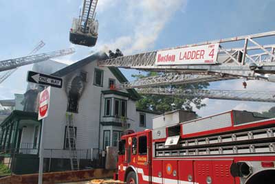 (2) A four-alarm fire in Boston's Jamaica Plain section emphasizes that every aerial must find its own access to the roof Bill Noonan</i>