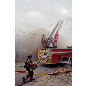 (1) Members set up to use a large-caliber stream from an aerial ladder as another member brings large-diameter hose to supply the water Kevin Brautlacht