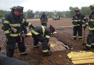 A senior firefighter shows new firefighters how critical it is to vent a metal deck roof without compromising the roof's structural integrity. (Photos by author.)