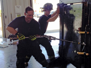  A senior firefighter demonstrates the one-person technique to force a metal door.