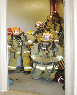 (1) Congestion at the attack stair landing inhibits evacuees' descent. Traffic must be stopped at the reentry floor above and tenants must be directed to cross over to the opposite stair. Ensure the route is not obstructed by a secure floor area. (<i>Photos courtesy of Massey Enterprises, Inc.</i>)