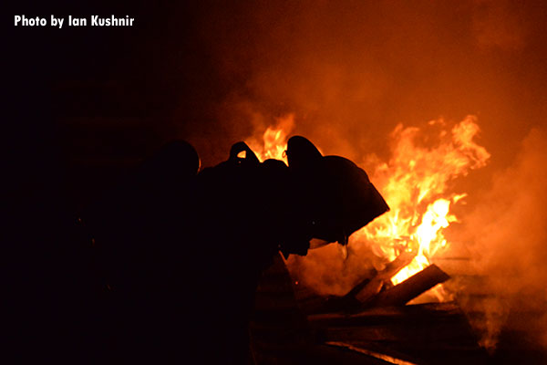 A firefighter silhouetted by flames during a fire in Dearborn, Michigan.