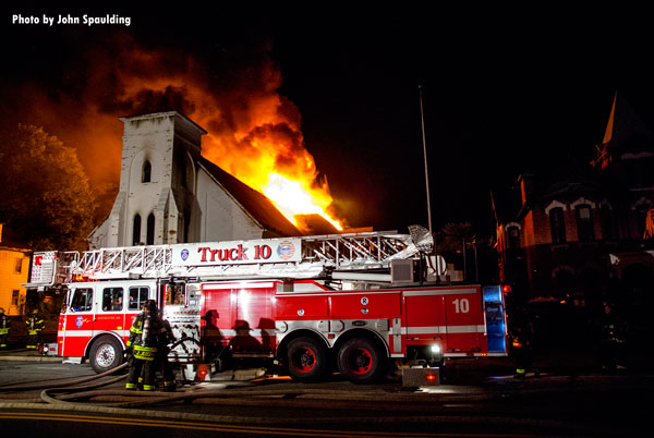 Fire apparatus parked in front of a burning church in Rochester, New York.