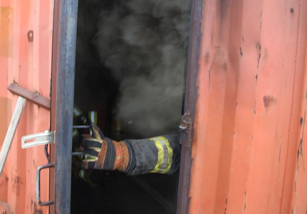 A firefighter emerges from a flashover simulator. Photo by Tony Greco.