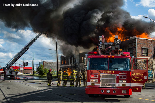 Detroit firefighters and apparatus at the scene of a commercial building fire.