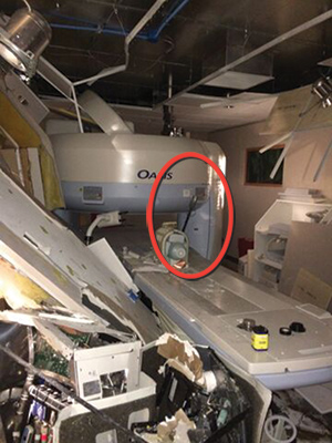 (5) The interior of the MRI suite. The tractor cab damaged the left wall. The circle shows the halligan that the magnetic field pulled out of the firefighter's hands.