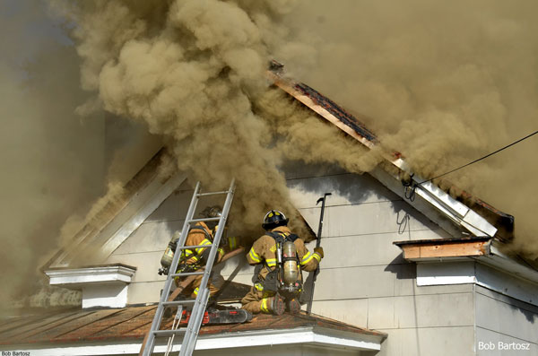 Firefighters perched outside a window venting smoke during a house fire in Rocky Mount, North Carolina.