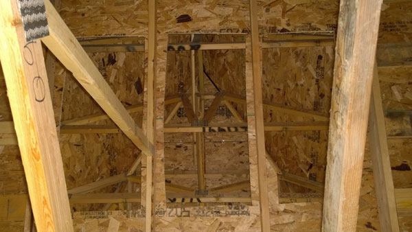 A photograph of the lightweight framing commonly found in modern dormers, a frequently used purchase point for personnel conducting vertical ventilation operations.  