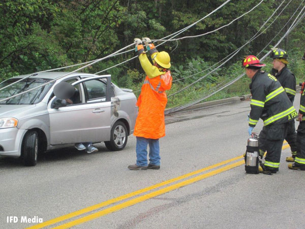 Indianapolis firefighters participate in the rescue of a man whose car was trapped under down power lines.