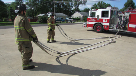 (7) As the nozzle firefighter stretches the attack hoseline, the backup firefighter has pulled the backup firefighter loop and is stretching the remaining hose. The 