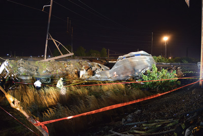 (9) Looking down from the Main Line on the crash site. At bottom right is the hoseline stretched to the scene to protect the responders and the passengers in case of fire. It also guided the walking wounded to the East Division patient treatment area. On the right is car 1, marked with orange spray paint; car 2, overturned, is on the far left.