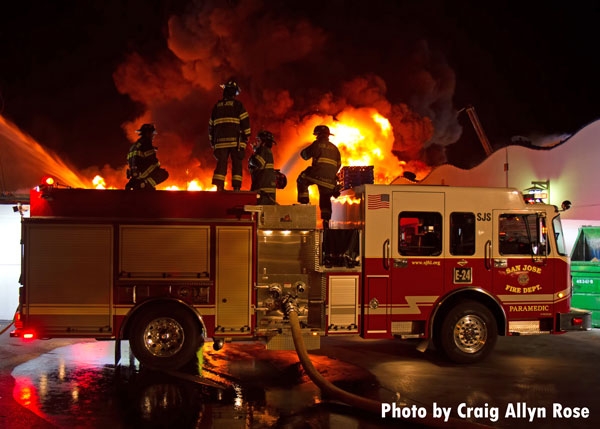 Firefighters on an apparatus during a four-alarm fire that destroyed a market in San Jose, California.