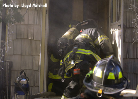 FDNY firefighters at the door of a Brooklyn home involved in a fire.